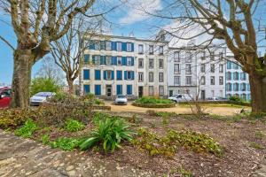 a large white building with blue windows in a park at Les Capucins - T2 tout confort in Brest