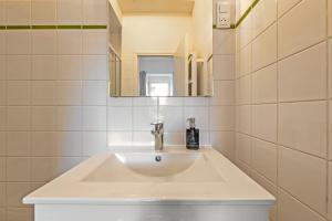 a bathroom with a white sink and a mirror at Les Capucins - T2 tout confort in Brest +13 photos