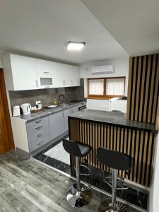 a kitchen with a counter and two bar stools at Stan na dan Apartman Durakovic in Cazin