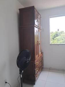 un grande mobile di legno con un ventilatore in una stanza di Meu aconchego a Belém