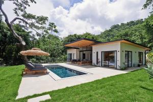 a villa with a swimming pool and a house at Ocean view Villa Alba 4ensuite rooms Malpais Santa Teresa in Mal País