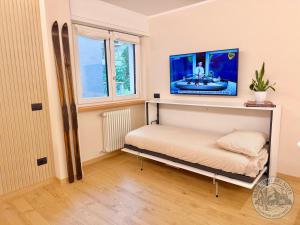 a room with a bed with a tv on the wall at Madesimo Ski Suite in Madesimo +2 photos