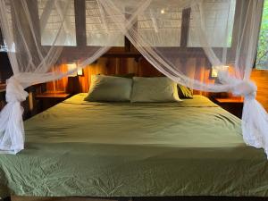 a bed with mosquito netting over it in a bedroom at Cabaña DREAM HOUSE in San Agustinillo