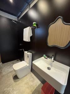 a bathroom with a white toilet and a sink at The Glamp - Homagama in Talagala
