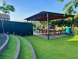 a picnic table under a canopy in a garden at The Glamp - Homagama in Talagala