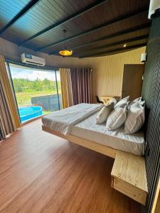 a bedroom with a bed and a large window at The Glamp - Homagama in Talagala