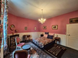 a living room with a bed and a chandelier at Le manoir d'Estiveaux in Le Châtelet