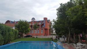 a large house with a swimming pool in front of it at Hotel Satelit Kumanovo in Kumanovo