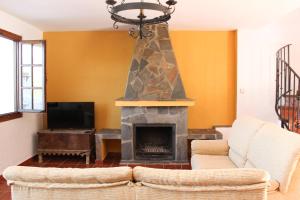 a living room with a fireplace and a couch at El Rincón de Muñoz - La Alpujarra in Yegen +94 photos