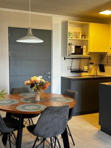 a kitchen with a table with a vase of flowers on it at innovador departamento cercano a mall y carretera in Rancagua