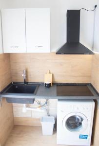 una cucina con lavello e lavatrice di AriaHome a Milano