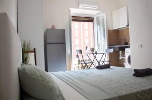 una camera con letto e una cucina con finestra di AriaHome a Milano