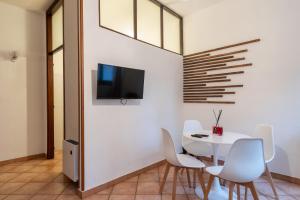 a dining room with a white table and white chairs at Ticinum House in Pavia