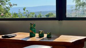 a table with three green vases on it with a window at Fincas del Faldeo in Villa General Belgrano +58 photos