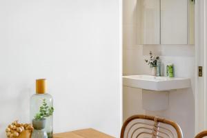 a small kitchen with a sink and a table at 803 - Stylish Retreat - Ocean Views & Parking in Newcastle