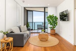 a living room with a couch and a table at 803 - Stylish Retreat - Ocean Views & Parking in Newcastle +8 photos