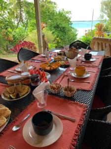 a long table with plates of food on it at Pension Vaimano-Raivavae in Vaiuru