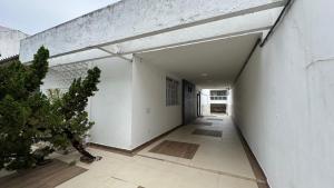 ein leerer Flur eines Gebäudes mit einer weißen Wand in der Unterkunft Hospedar Imperial in Campina Grande