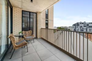 a balcony with two chairs and a table at Civic - Civic Central in Newcastle