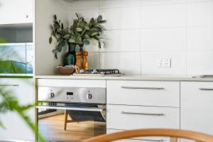 a kitchen with white appliances and a vase of plants at 901 - Perfect Penthouse - With Free Parking in Newcastle