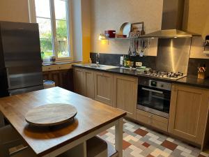 a kitchen with a wooden table and a stove at La Fumacienne in Fumay