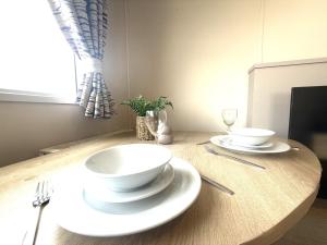 a table with two white plates and silverware on it at Grand Horizon in Hunmanby +71 photos