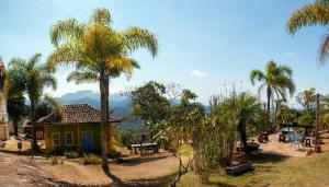 a small house with palm trees in front of it at Pousada Vila Mineira in Lavras Novas +53 photos