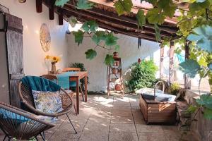 a patio with a table and chairs and a table at Romantic Cottage Retreat for Two in South Vienne in Champniers