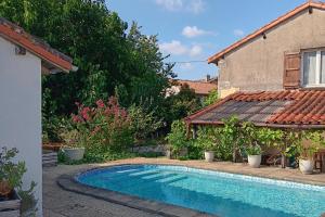 a swimming pool in a yard next to a house at Romantic Cottage Retreat for Two in South Vienne in Champniers