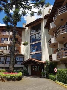 Un gran edificio con un árbol delante. en Valor inacreditável para Ano Novo com vista e perto de tudo, en Gramado