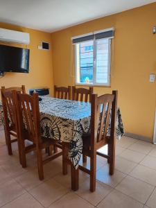 a dining room table with chairs and a tablecloth on it at Kaike in Caleta Olivia +11 photos