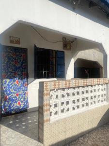 a building with a wall with a gate and a door at Brikama line house in Brikama