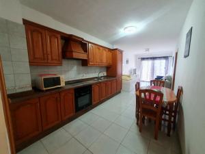 a kitchen with wooden cabinets and a table with chairs at Los Llanos Ocean view in Los Llanos de Aridane