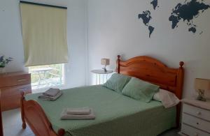 a bedroom with a bed with green sheets and a map on the wall at Los Llanos Ocean view in Los Llanos de Aridane