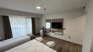 a hotel room with two beds and a flat screen tv at Мотел Ханай 