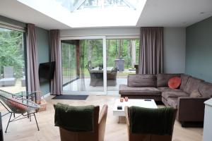 VilsterenにあるKindvriendelijke bungalow in het bos bij zwemmeer.のソファとテーブルのあるリビングルーム