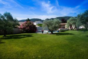 a yard with green grass and trees and a house at Maison L'oustalette De Mau-bé in Maubec