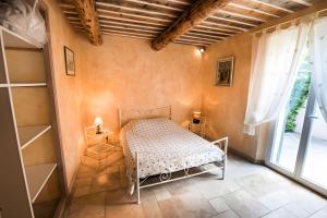 a bedroom with a bed in a room with a window at Maison L'oustalette De Mau-bé in Maubec