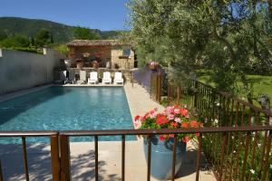 a swimming pool with chairs and flowers on a balcony at Maison L'oustalette De Mau-bé in Maubec +11 photos