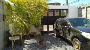 a car parked next to a building with a tree at Cazartes antiguo in Treinta y Tres