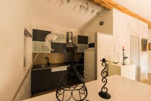 a kitchen with black cabinets and a white counter top at Maison L'oustalette De Mau-bé in Maubec