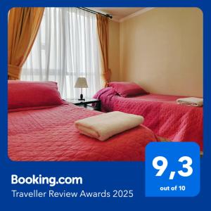 une chambre d'hôtel avec deux lits avec des couvertures rouges dans l'établissement Arriendo departamento en La Serena Central, à La Serena