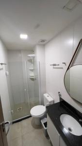 Un baño con inodoro, lavabo y espejo. en LOFT VISTA MAR - Orla da Praia Grande, en Arraial do Cabo 24 fotos más