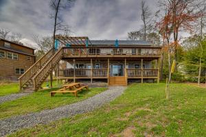 a large wooden house with a picnic table in front of it at Lakefront Pocono Retreat with Hot Tub and Movie Hub in Pocono Summit Estates