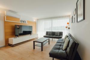 a living room with a couch and a tv at Amazing Pool Apartments by Vacationy in Vila Nova de Gaia