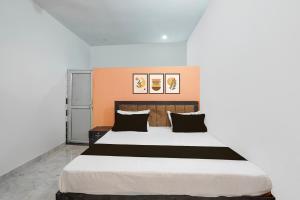 a bedroom with a large bed with black pillows at Hotel O Raj Family Restaurant & Hotels in Mahmūdnagar