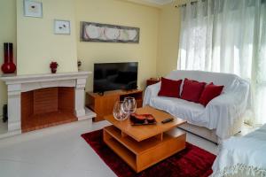 un salon avec un canapé et une télévision dans l'établissement Vila das Conchas - Enjoy the Seaview Pool with the Beach only steps away, à Sesimbra