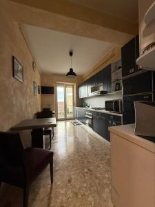 eine Küche mit schwarzen Schränken, einem Tisch und Stühlen in der Unterkunft B&B 814 Fermo in Fermo