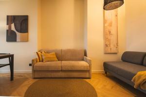 トリノにあるDomus Nova - Una finestra sui tettiのソファと椅子のあるリビングルーム