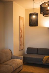 トリノにあるDomus Nova - Una finestra sui tettiのソファと椅子のあるリビングルーム